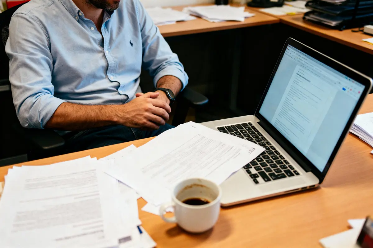 pexels-michal-pech-213601-757318 (1) Homme au bureau avec ordinateur portable, papiers et tasse de café.