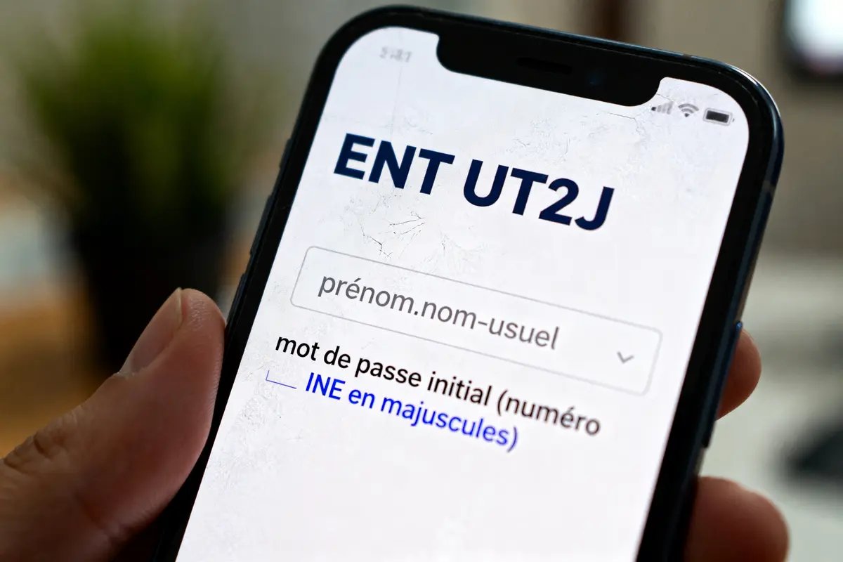 Smartphone affichant l'écran de connexion ENT UT2J avec champs identifiant et mot de passe.
